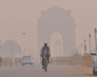 New Delhi: A man wears a mask as he paddles through the smog-covered Rajpath in New Delhi on Nov 8, 2018. 