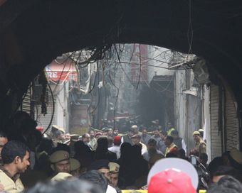 New Delhi: Onlookers with police personnel at the area of a fire incident in which 43 people died in West Delhi